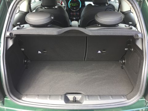 2001 Ford Crown Victoria - The open trunk of a green Mini Cooper is shown, revealing the carpeted cargo area and the rear seats folded down.