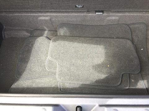 2001 Ford Crown Victoria - The interior of a car trunk shows dark gray carpet floor mats laid out. The mats are arranged in a way that suggests they are custom-fit fo…