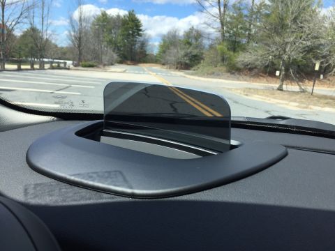 2001 Ford Crown Victoria - The interior of a car shows a head-up display unit mounted on the dashboard, reflecting the road and trees outside. The view is from the dr…