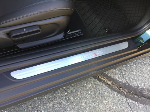2001 Ford Crown Victoria - A close-up view of the interior door sill of a car, showing a brushed metal accent plate with the text "MINI COOPER S" and checkered flag g…