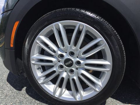 2001 Ford Crown Victoria - A close-up view of a silver multi-spoke alloy wheel with the MINI logo on a tire. The wheel is mounted on a vehicle with a dark fender and…