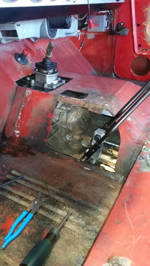 1968 Ford Bronco - The interior of a vintage vehicle, likely a 1968 Ford Bronco, shows the transmission tunnel with a manual shifter and transfer case visible…