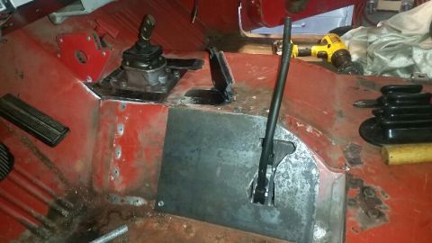 1968 Ford Bronco - The interior of a classic vehicle shows a red floor with a new metal plate installed around the shifter mechanism. Visible parts include pe…