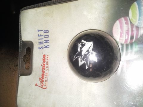 1968 Ford Bronco - A black shift knob with a white shark graphic is shown in its packaging. The packaging indicates it is a shift knob from American Shifter C…