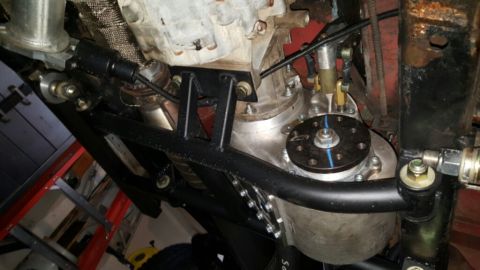1968 Ford Bronco - A low-angle view of the underside of a vehicle's drivetrain, showing a transfer case, transmission, and exhaust components mounted to a cus…