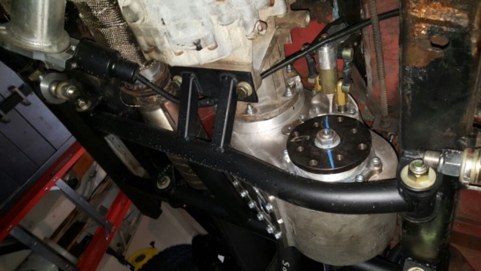 Underside view of vehicle drivetrain with transfer case, transmission, and exhaust.