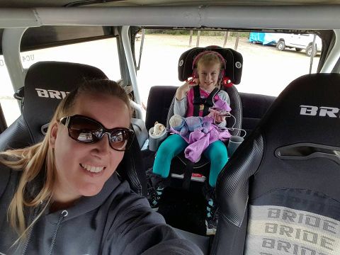 1968 Ford Bronco - A woman in sunglasses takes a selfie in the front seat of a vehicle, with a young girl in a car seat behind her. The vehicle appears to be…