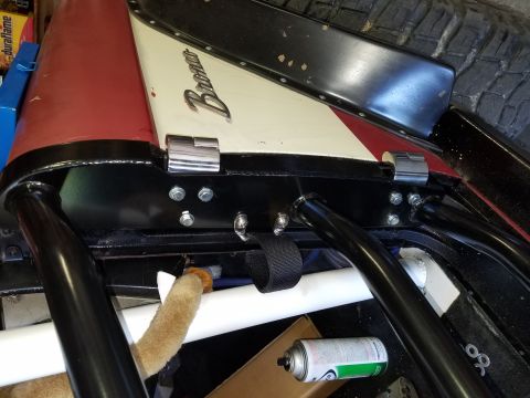 1968 Ford Bronco - Close-up view of the rear interior of a classic Ford Bronco, showing a roll cage, a black and white interior panel with red accents, and ch…