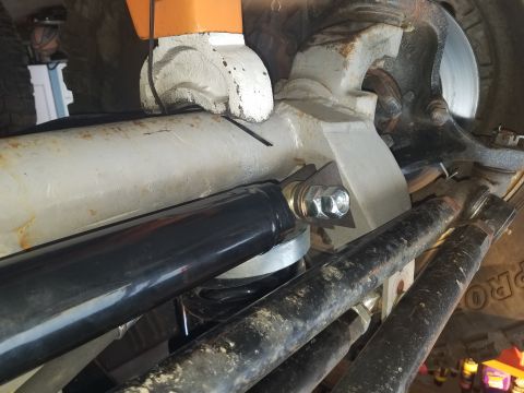 1968 Ford Bronco - A close-up view of the suspension system of a vehicle, likely a 1968 Ford Bronco, showing a black shock absorber mounted to a white suspens…