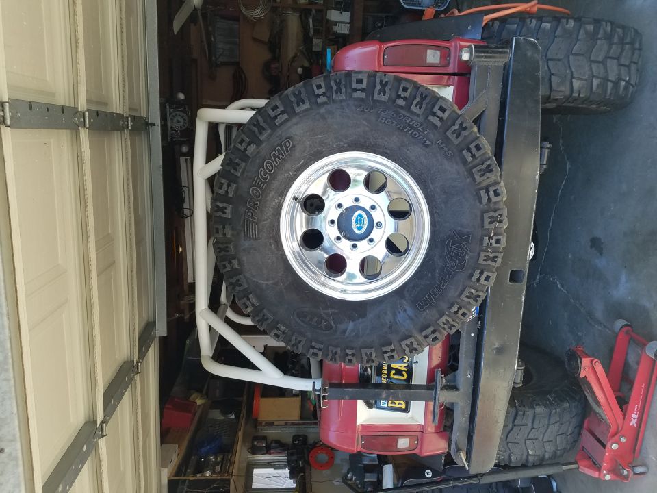 Red off-road vehicle with spare tire and roll cage in garage