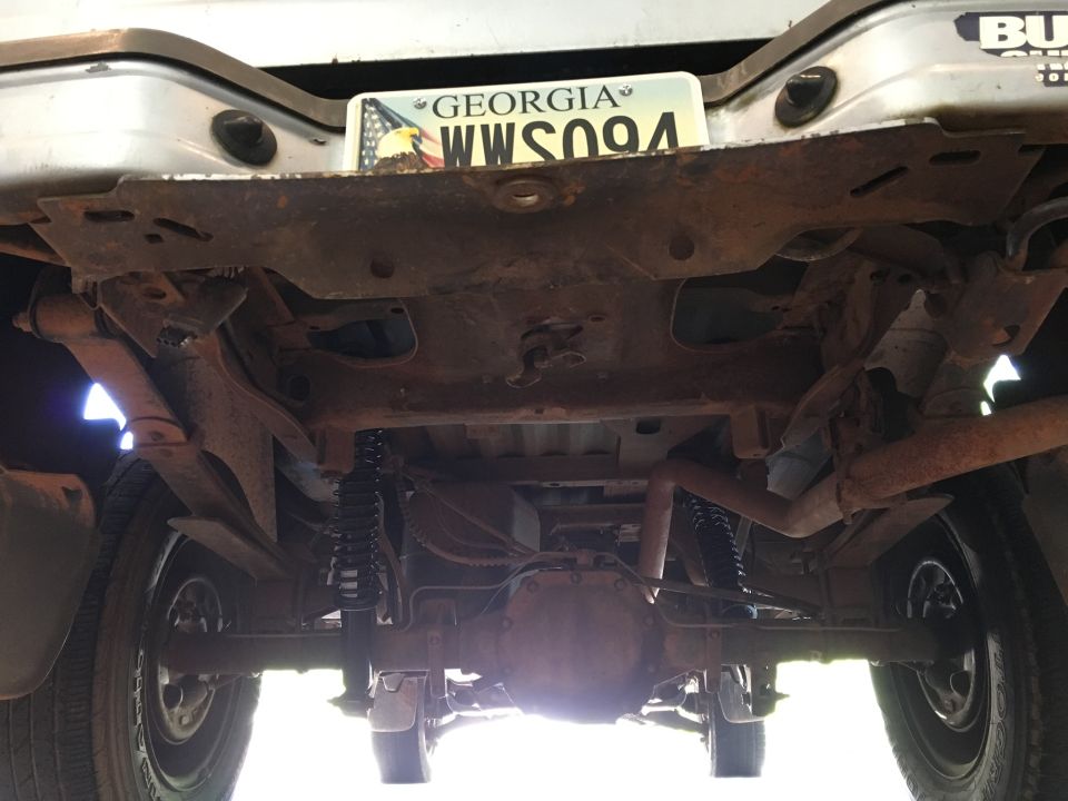 Underside of a 1998 Ford Ranger showing rear axle, suspension, exhaust, and license plate.