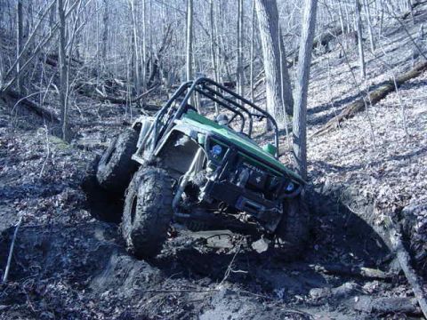 1992 Ford Bronco - This off-road vehicle appears to be stuck in a muddy ditch on a wooded hillside.