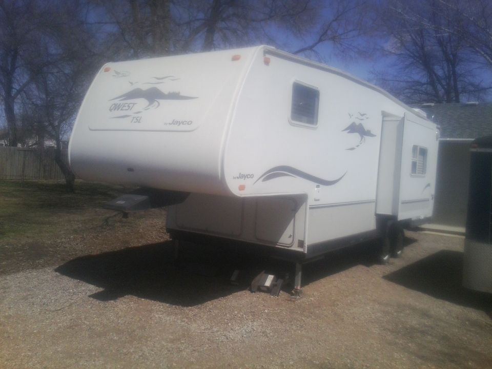White Jayco Qwest TSL fifth-wheel RV parked outdoors.