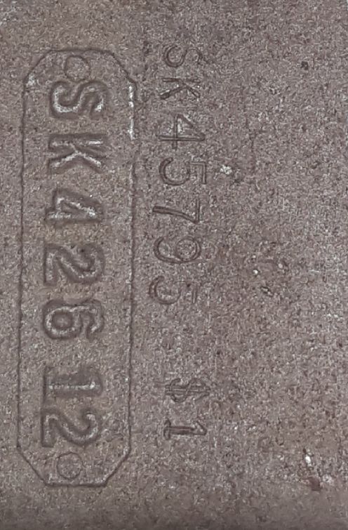 Stamped metal with text SSK42612 and SK45793 S1