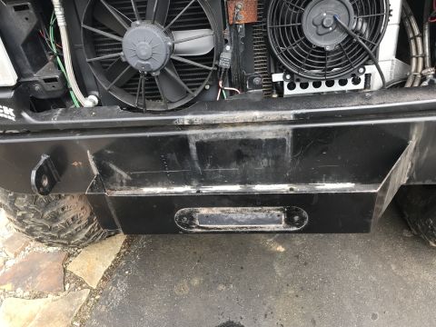 1989 Ford Bronco - A close-up view of the front bumper and grille area of a modified off-road vehicle, featuring two electric fans mounted in front of the rad…
