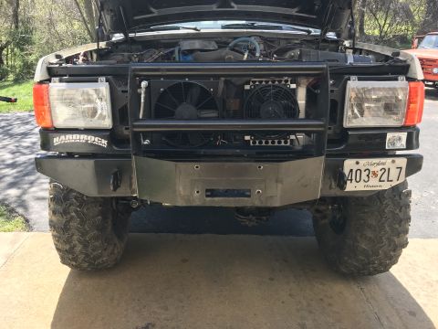 1989 Ford Bronco - The front view of a lifted Ford Bronco with an aftermarket grille guard and winch bumper. The vehicle has large off-road tires and a Maryla…