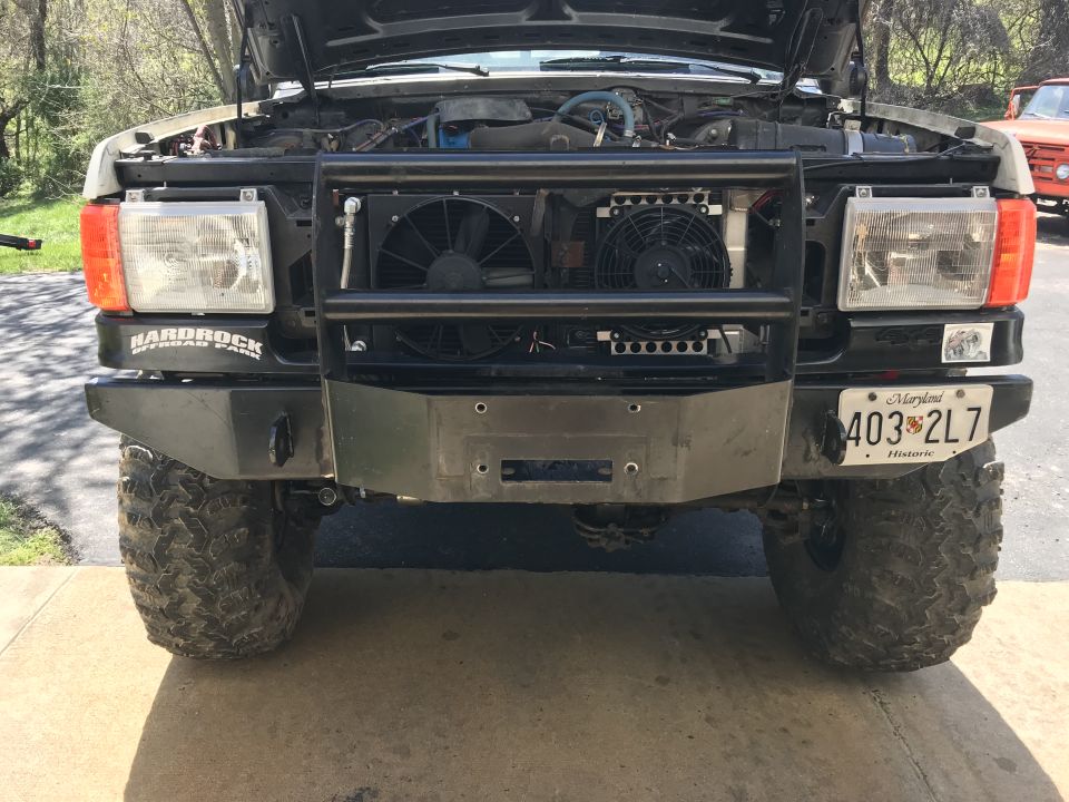 Front view of a lifted Ford Bronco with grille guard, winch bumper, and off-road tires.