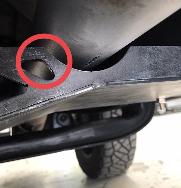Underside of a 1995 Ford Bronco skid plate with a red circle around a cut-out.