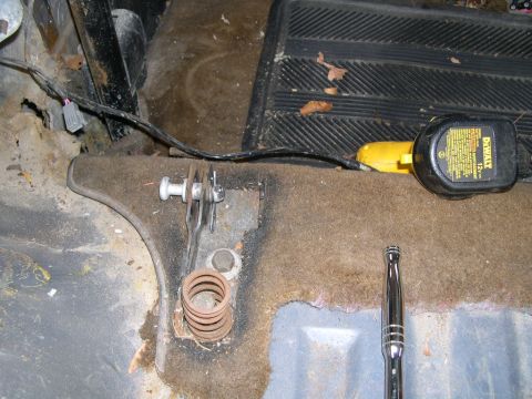 1986 Ford Bronco - Vehicle interior floor shows rust damage and tools, including a DeWalt tape measure and a socket extension.