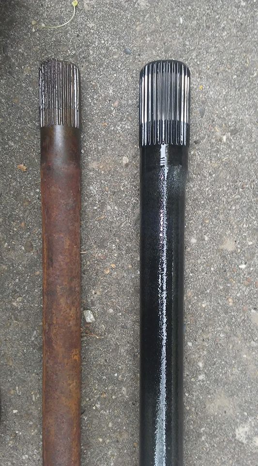 Rusty driveshaft next to a black painted driveshaft