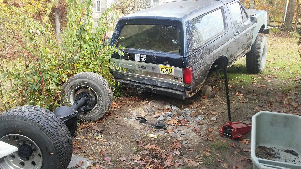 Ford Bronco with rear axle removed, jack, and spare tire.