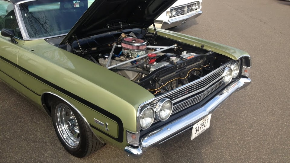 1968 Ford Ranchero with hood open, showing engine, light green with black stripe.