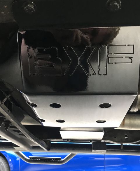 1995 Ford Bronco - A black metal skid plate with the letters "BXF" etched into it is mounted underneath a vehicle. The plate has four circular cutouts and is…