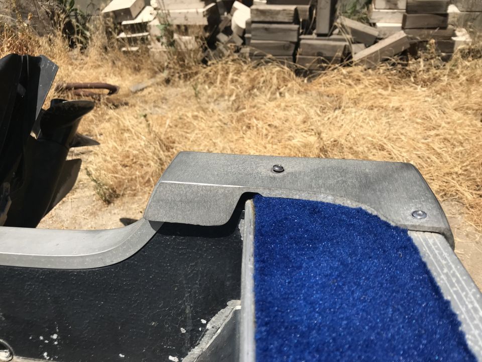 Blue carpeted step and gray metal trim on a boat or trailer.