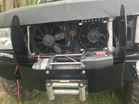 1989 Ford Bronco - The front of a 1989 Ford Bronco features a winch and dual cooling fans mounted behind a custom bumper.