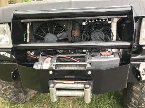 1989 Ford Bronco - Vehicle front end shows a winch, radiator, and cooling fans mounted behind a bull bar.