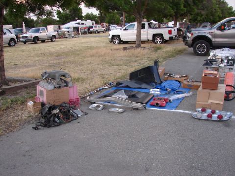 1973 Ford Ranchero - Various car parts are displayed for sale at an outdoor event, with multiple vehicles in the background.