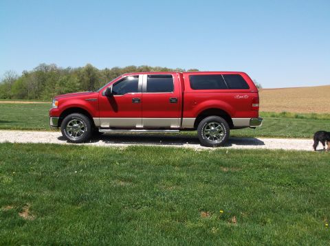 2008 Ford F-150 - Side view of a red 2008 Ford F-150 pickup truck equipped with a tan lower body and a matching camper shell.