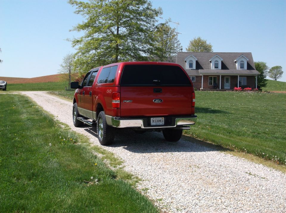 Red 2008 Ford F-150 pickup truck with camper shell, rear view