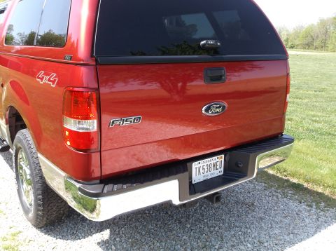 2008 Ford F-150 - Rear view of a red 2008 Ford F-150 pickup truck equipped with a bed cap.