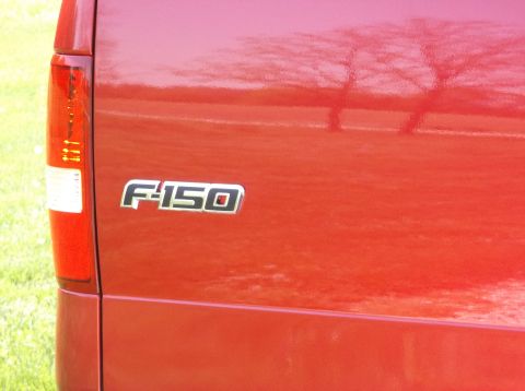 2008 Ford F-150 - Close-up of the F-150 badge on the tailgate of a red truck.