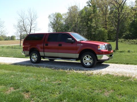 2008 Ford F-150 - This red pickup truck, equipped with a cap, is shown from a 3/4 front angle.
