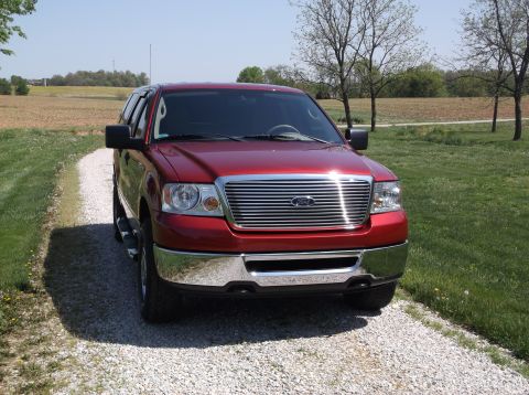 2008 Ford F-150 - Front view of a red 2008 Ford F-150 pickup truck parked on a gravel driveway.