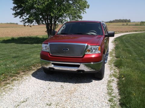 2008 Ford F-150 - Front view of a red 2008 Ford F-150 pickup truck parked on a gravel driveway.