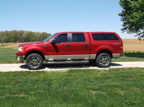2008 Ford F-150 - A red pickup truck with a tan two-tone paint scheme and a matching cap is parked outside on a sunny day.