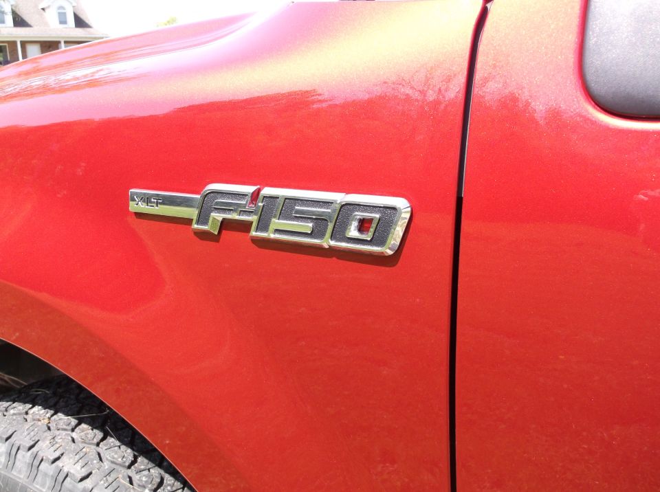 Close-up of 2008 Ford F-150 fender badge on red truck