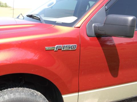 2008 Ford F-150 - Close-up view of the fender and side mirror on a red truck, showing the F-150 badging.