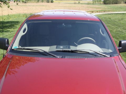 2008 Ford F-150 - The front of a red pickup truck is shown, focusing on the hood and windshield area. The interior is partially visible.