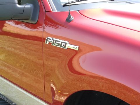 2008 Ford F-150 - F-150 XLT badge on the fender of a red truck.