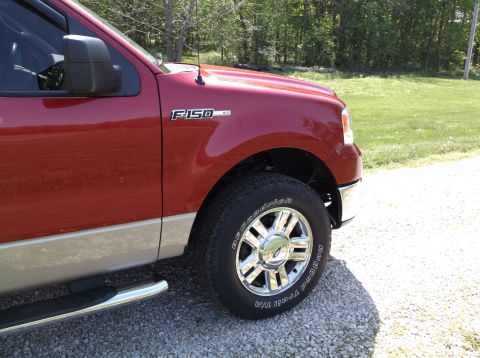 2008 Ford F-150 - A red Ford F-150 truck is shown from the front quarter angle, highlighting its chrome wheels and two-tone paint.