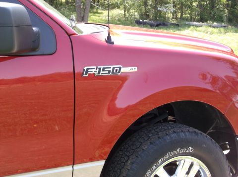 2008 Ford F-150 - Close-up of the fender and tire on a red 2008 Ford F-150 XLT truck.