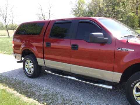 2008 Ford F-150 - Side view of a red Ford F-150 pickup truck with a cap, showing its two-tone paint and running boards.