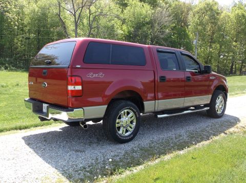 2008 Ford F-150 - This red 2008 Ford F-150 pickup truck is equipped with a cap and seen from its rear-three-quarter view.
