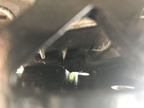 1989 Ford Bronco - Close-up view of a vehicle's transfer case showing a leak of green fluid.