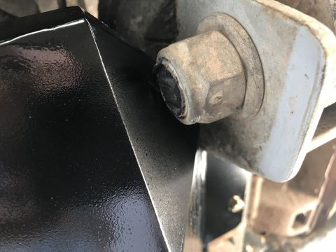 1989 Ford Bronco - Detail of a black metal component and a bolt, possibly related to a vehicle's transfer case.