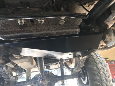 1989 Ford Bronco - Vehicle underbody with skid plate installed over the transfer case and suspension parts.